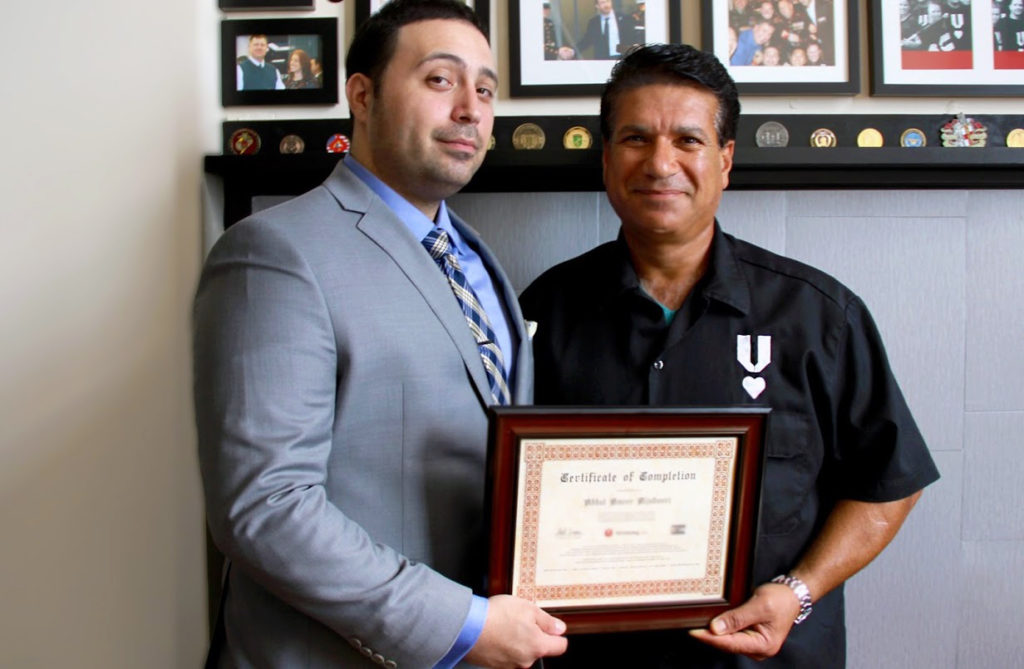 Standing to the right of his VRL mentor Christian Zamora, is Ameer, holding his OSHA training certification, after completing his exam.