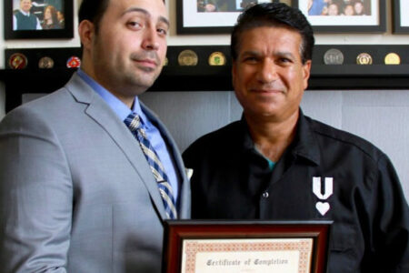 Standing to the right of his VRL mentor Christian Zamora, is Ameer, holding his OSHA training certification, after completing his exam.