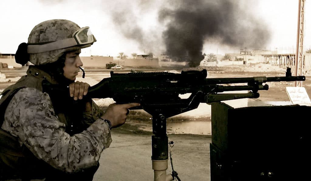 U.S. marine Dre Popow seern here manning a 240 heavy machine gun following a firefight.
