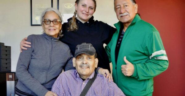 Centered below: Army Veteran Alonzo Mills, surrounded by loved ones, at Veterans Rebuilding Life offices in Queens, NY.