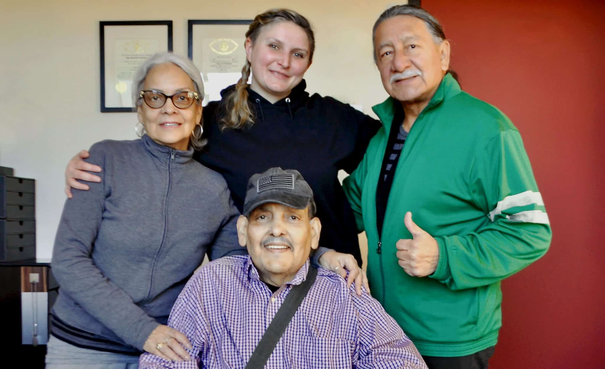 Centered below: Army Veteran Alonzo Mills, surrounded by loved ones, at Veterans Rebuilding Life offices in Queens, NY.